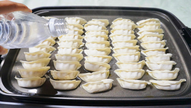 コストコの冷凍黒豚餃子(ホットプレートの上で焼いてから水を投入)