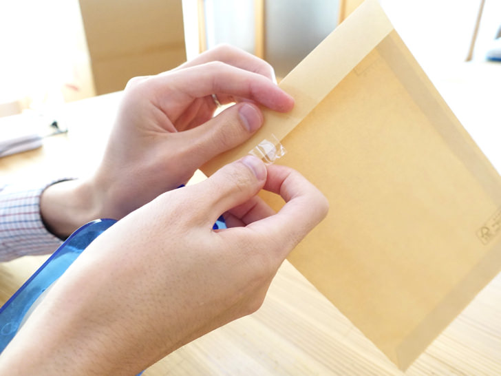 封筒をテープでとめる