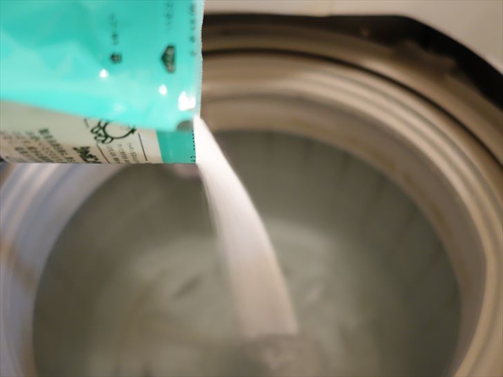 酸素系漂白剤を洗濯機に入れるところ
