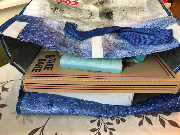 2枚の保冷剤に挟み、保冷バッグに入れた大型ピザ