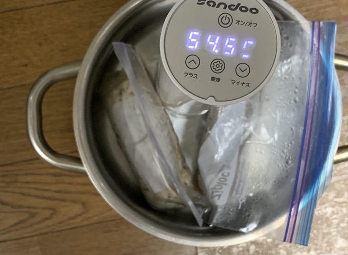 低温調理器をセットした鍋にジップロックに入った肉を入れている様子