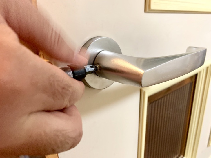 ドアの根元のネジをゆるめている様子